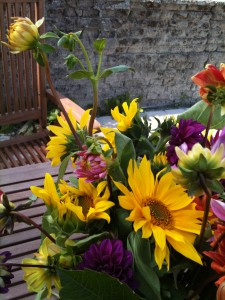 Blandet blomsterbuket på havebord.